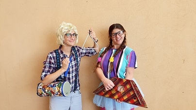 שתי שחקניות בתלבושות מצחיקות מחזיקות כלי נגינה
